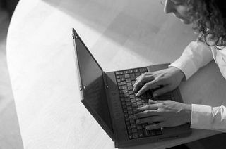 Caucasian businesswoman typing on black laptop computer